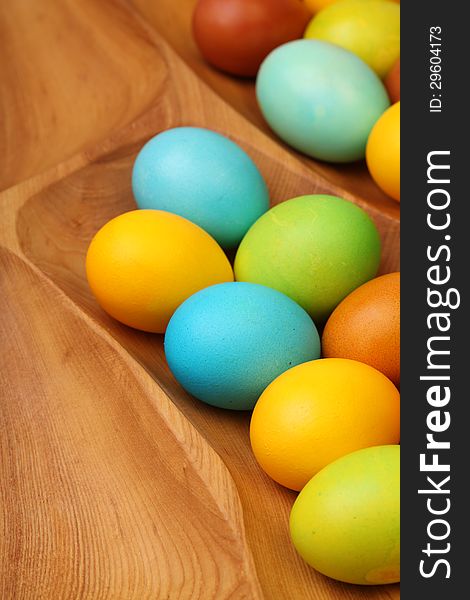 Colorful easter eggs in wooden tablemat.