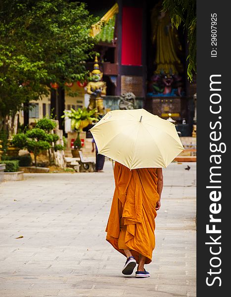 Buddhist monk with an umbrella at a Thai Temple