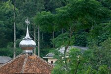 Image Of The Tile Roof Of A Small Mosque, With A Small Aluminum Dome On Top, In The Middle Of Green Forest Trees. Stock Photo