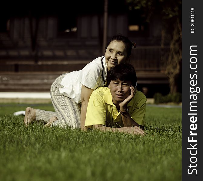 Portrait of beautiful couple lie on ground in park relaxing