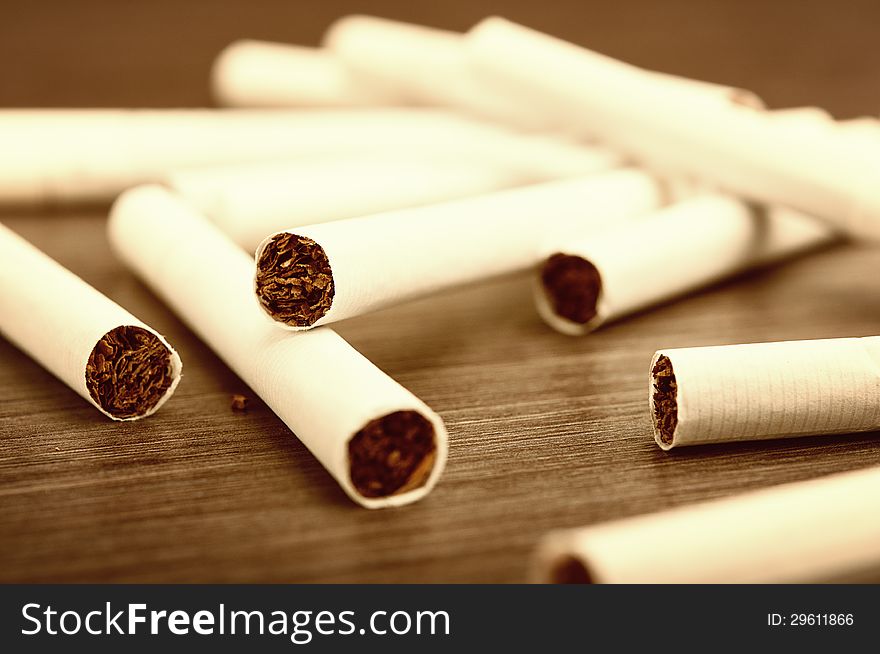 Heap of cigarettes and tobacco on a dark wooden background