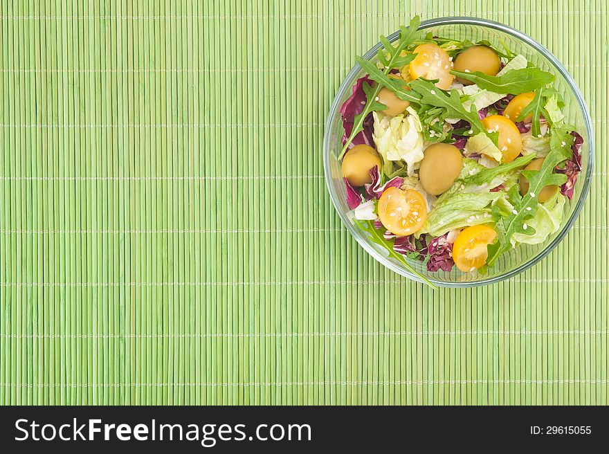 Vegetable salad on green background top view