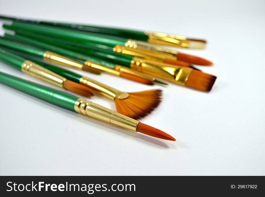 Many different type and size of paintbrushes on white background. Many different type and size of paintbrushes on white background