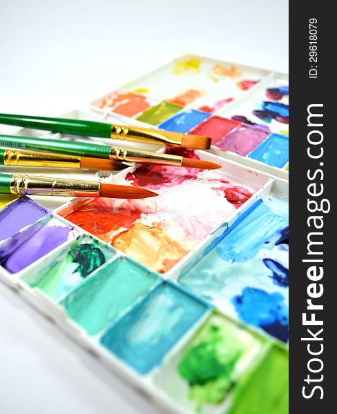 Colorful watercolor palette and diffent type of paintbrushes on white background. Colorful watercolor palette and diffent type of paintbrushes on white background