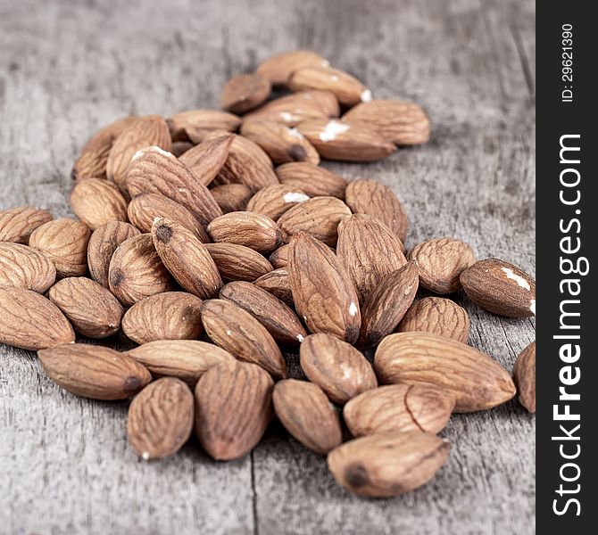 Roasted almonds on wooden table, food background