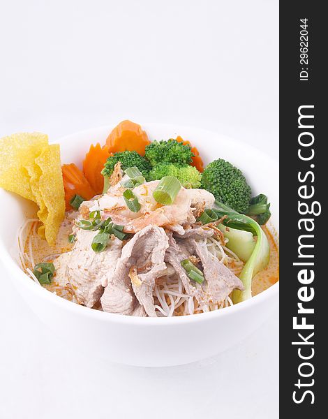 Laksa noodle soup with chicken, fresh vegetables and wonton on t