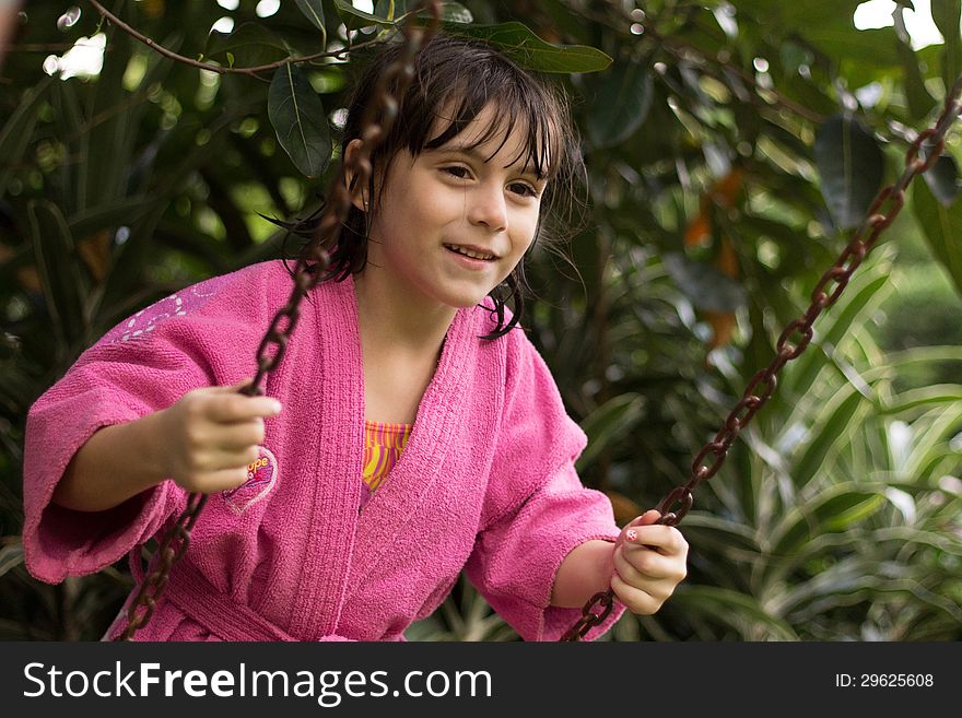 Cute happy little girl swinging