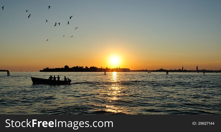 Anglers in boat fishing at sunset