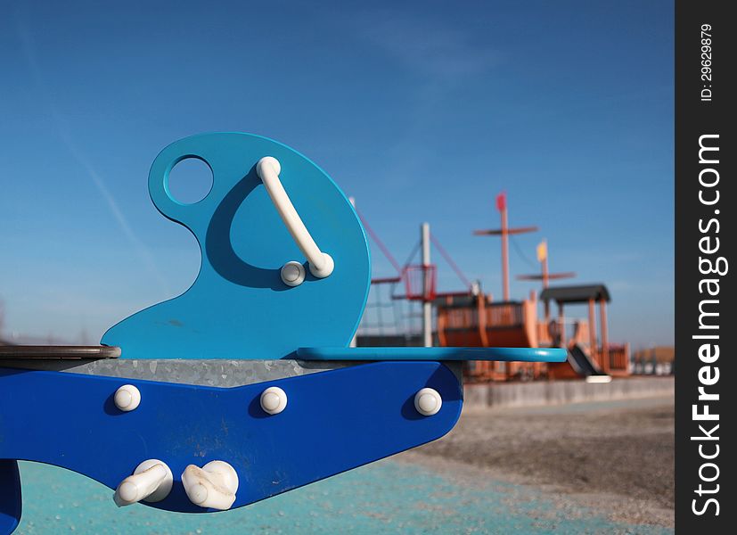 A blue rocking toy in a childrens playground. A blue rocking toy in a childrens playground.