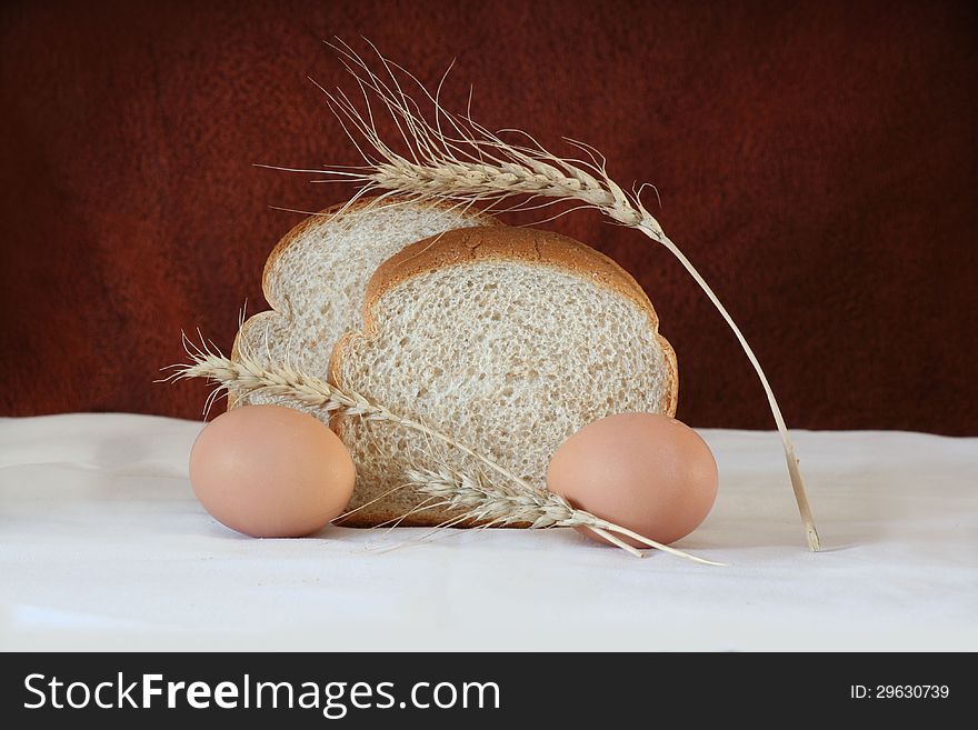 Brown bread and eggs surrounded by barley.