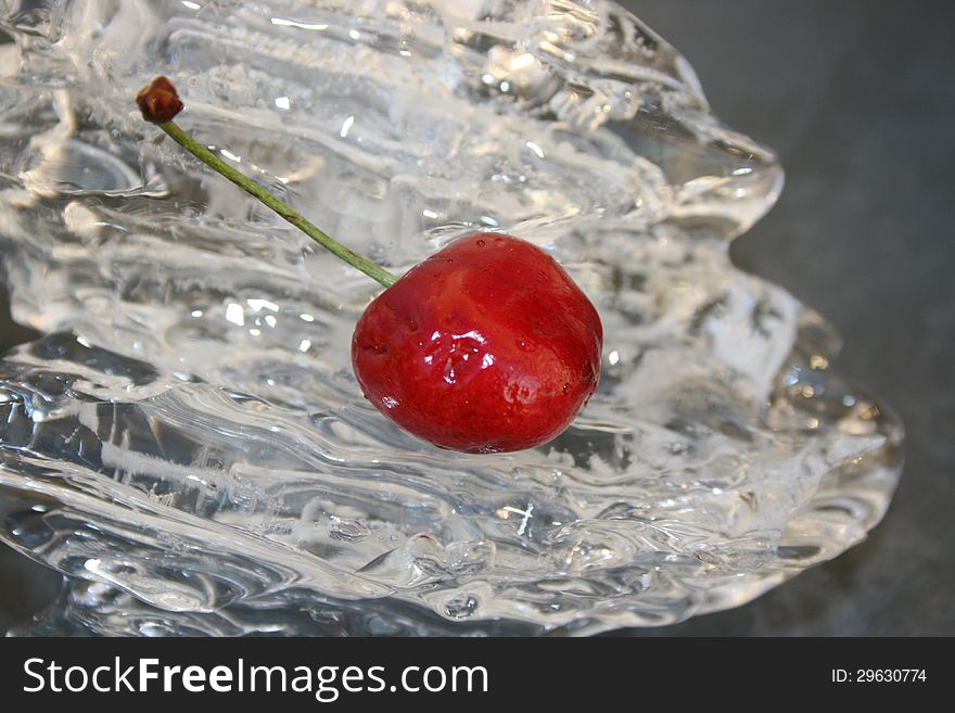 Single cherry laying on a piece of ice. Single cherry laying on a piece of ice.