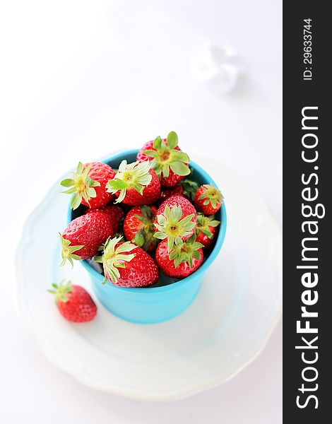 Blue pot with strawberries on white backgrownd