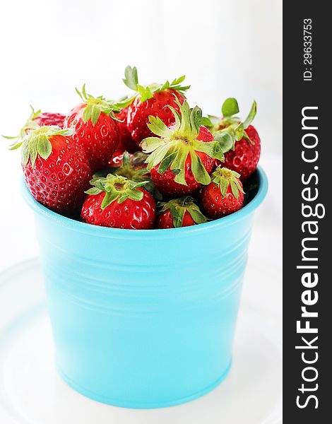 Blue pot with strawberries on white backgrownd