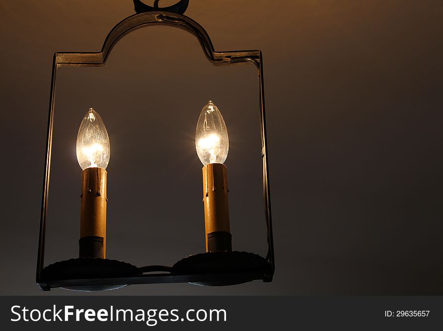 Soft electric lighting from candles on metal stands in dark room. Soft electric lighting from candles on metal stands in dark room.