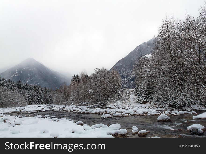 A winter landscape with river and mountain in the background. A winter landscape with river and mountain in the background