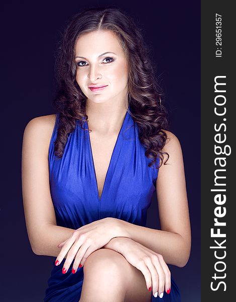 Young gorgeous brunette in blue silk dress posing in the studio. Young gorgeous brunette in blue silk dress posing in the studio