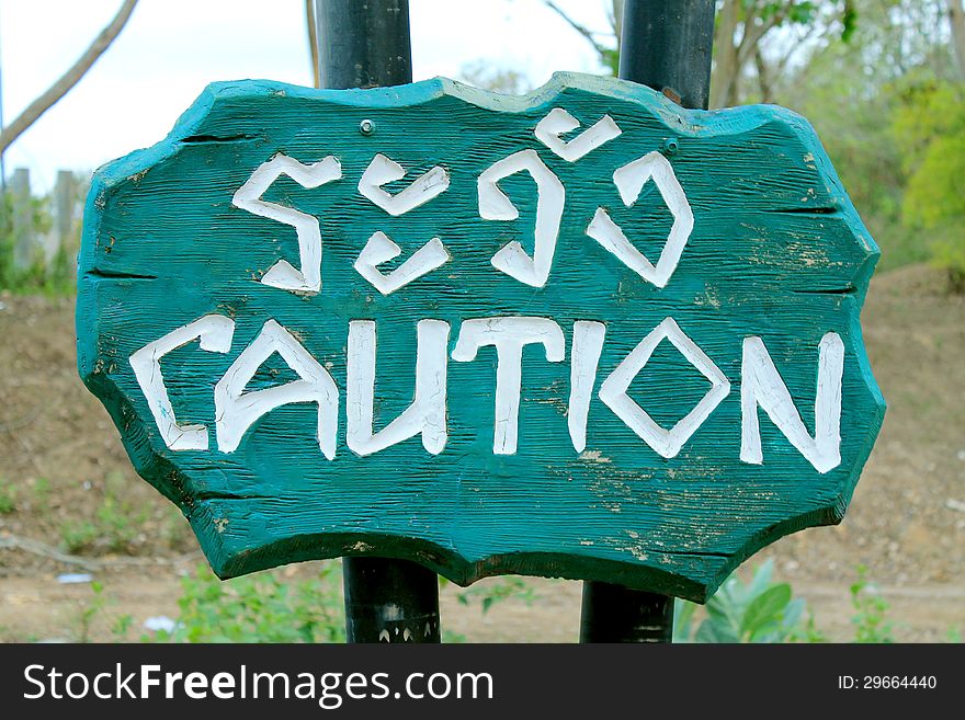 Caution Sign Thai and English Language on wooden sing