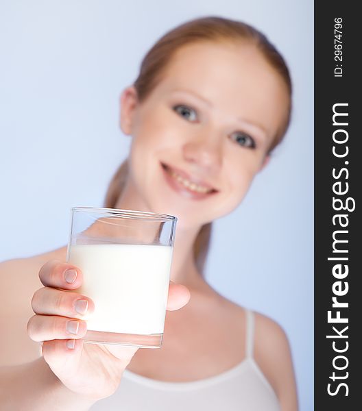 Beautiful healthy girl with a glass of milk on a blue background