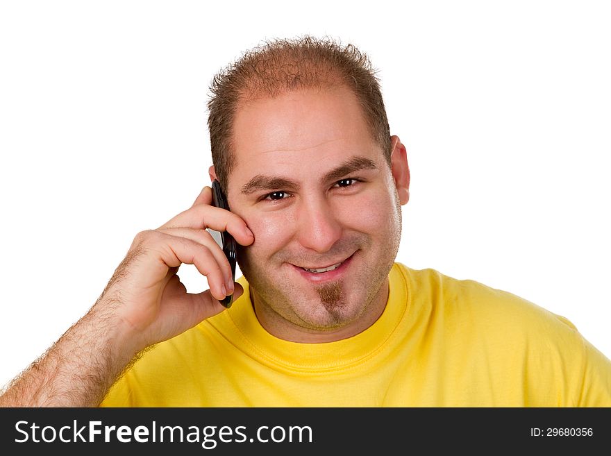 Young man in a yellow shirt on the phone - isolated. Young man in a yellow shirt on the phone - isolated