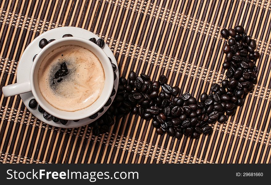 Cup of coffee with coffee beans on a wood table