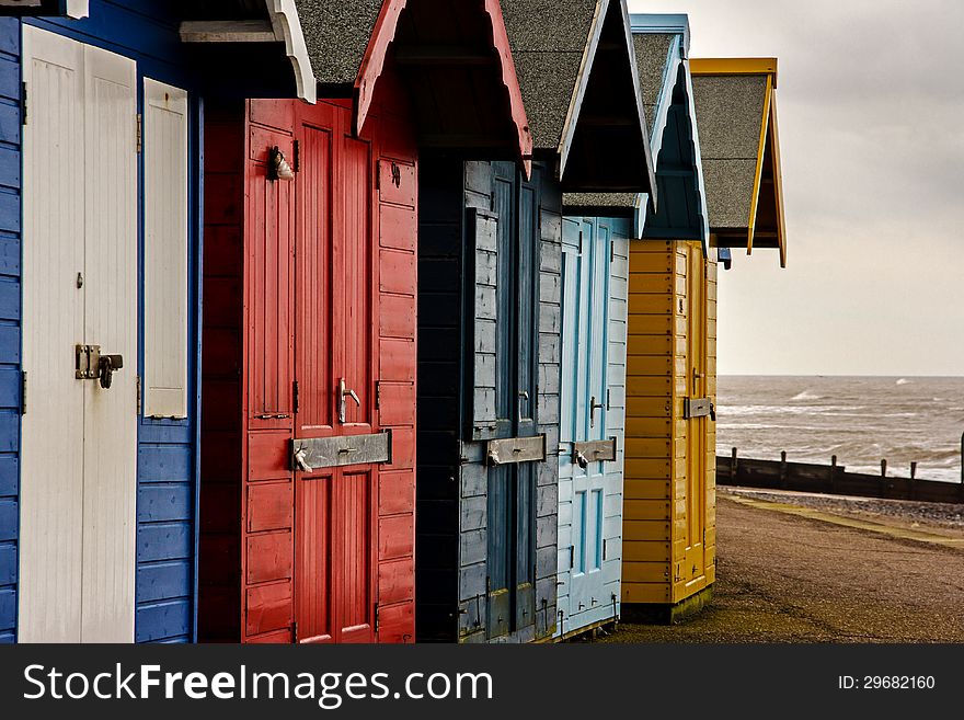Colorful beach huts during a blustery spring day on the boardwalk