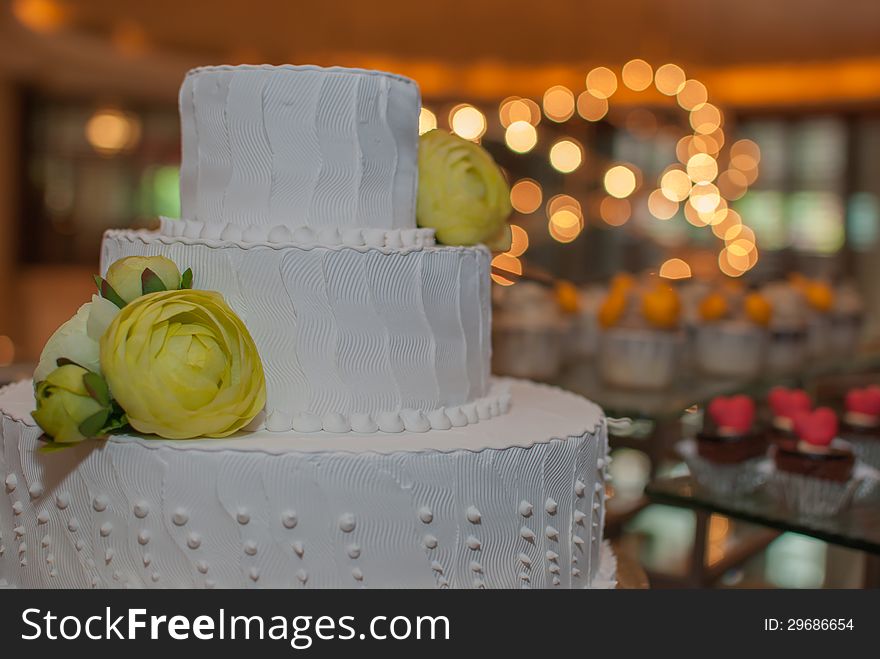 White Wedding cake with flower and light in background