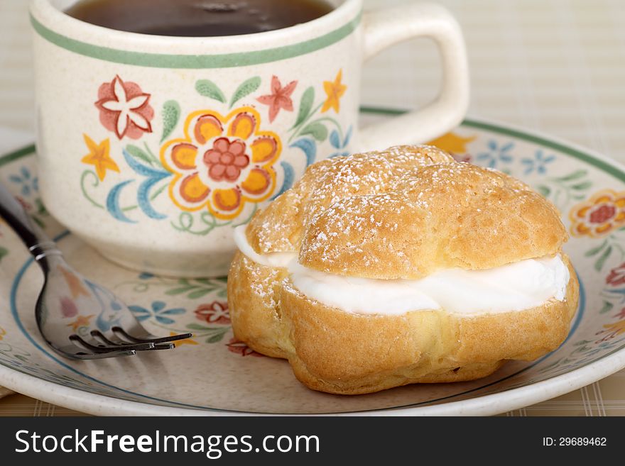 Cream puff on a plate with cup of coffee. Cream puff on a plate with cup of coffee