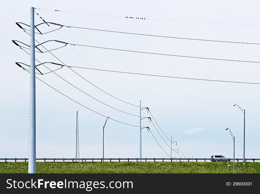 Landscape of poles with electric lines over highway with hybrid car. Landscape of poles with electric lines over highway with hybrid car.