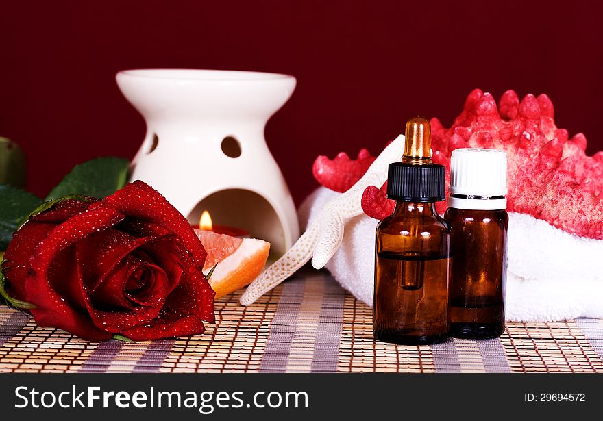 Essential oil and red rose a burning candle. Essential oil and red rose a burning candle