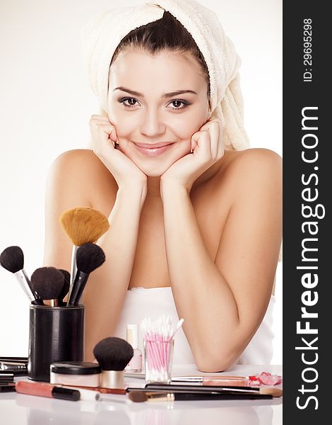 Smiling girl leaning on hands with a towel on her head on white background. Smiling girl leaning on hands with a towel on her head on white background