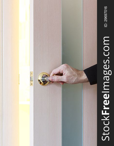 Man hand opening door in light room