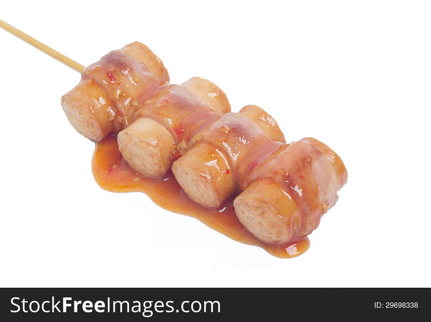 Closeup of hot dog with sauce on white background