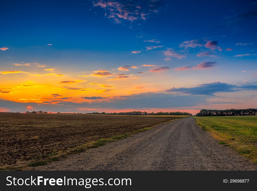 Road in meadows and beautiful sunset