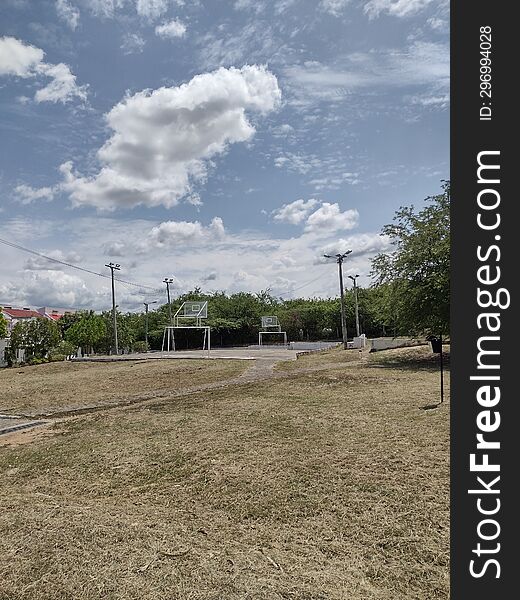 Outdoor Park With Grass And Blue Sky With Clouds