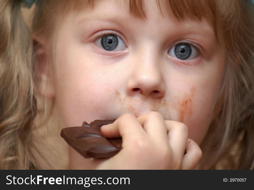 A girl eating a chocolate. A girl eating a chocolate