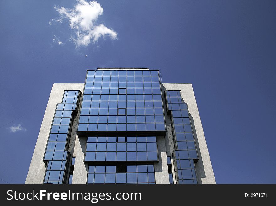 Office building and a small cloud on a blue sky