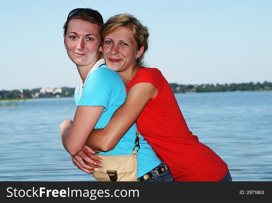 Two women stand together in a lake. Two women stand together in a lake