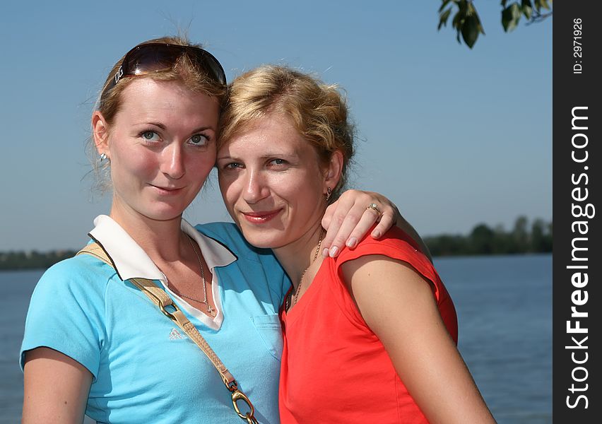 Two young women stand together in a lake. Two young women stand together in a lake