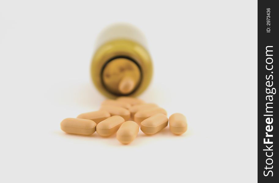 Pills and bottle on white background