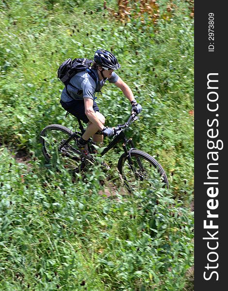 A cross country mountain biker on a trail photograhed using motion panning. A cross country mountain biker on a trail photograhed using motion panning