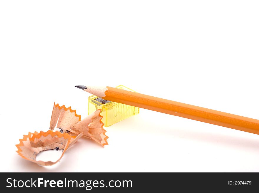 A sharpened pencil, the pencil sharpener and the shavings, isolated on white