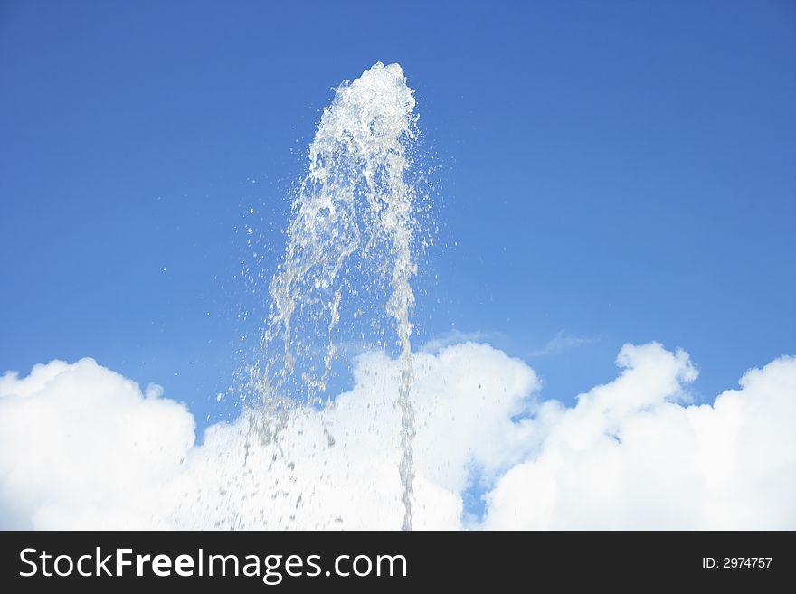 Fountain on a background of clouds and the dark blue sky