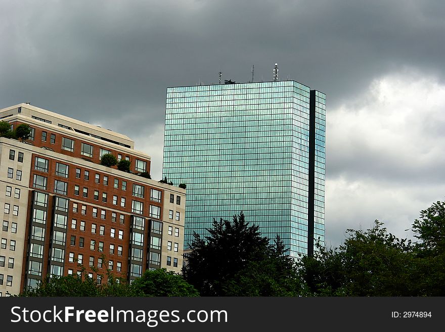 Storm clouds surround this large glass mirrored skyscraper building in boston's back bay. Storm clouds surround this large glass mirrored skyscraper building in boston's back bay