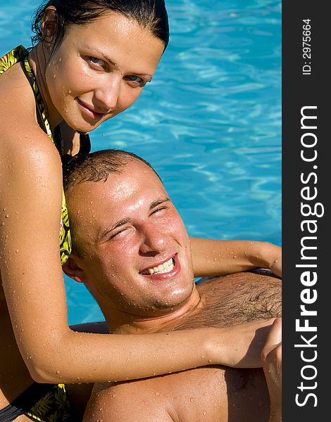 An attractive young couple relaxing by the pool. An attractive young couple relaxing by the pool