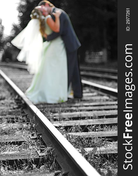 The groom and bride kiss on railway. The groom and bride kiss on railway