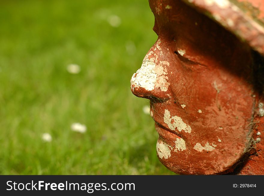 Photo of red stoned face on the grass