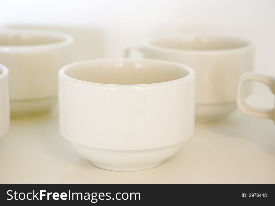 Empty Coffee Cups waiting to be filled. Focus on forward lip of cup. Shallow depth of field