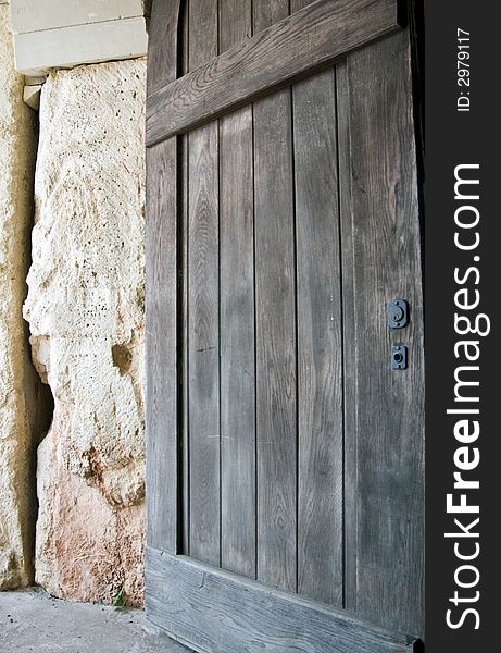 A large wooden door closed, and blocking entrance to the inside of the stone building. A large wooden door closed, and blocking entrance to the inside of the stone building