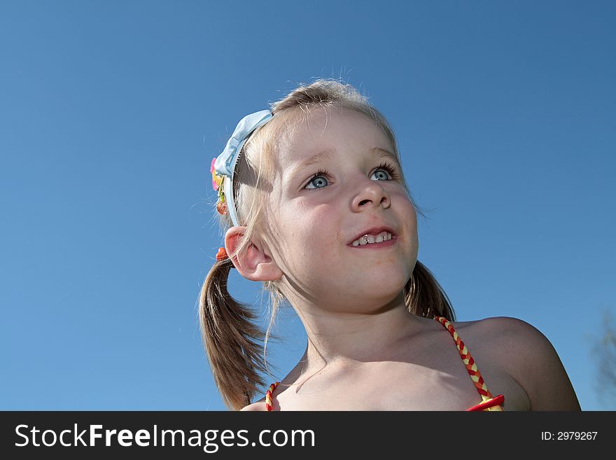 The happy girl smiles outdoor in the sky background. The happy girl smiles outdoor in the sky background