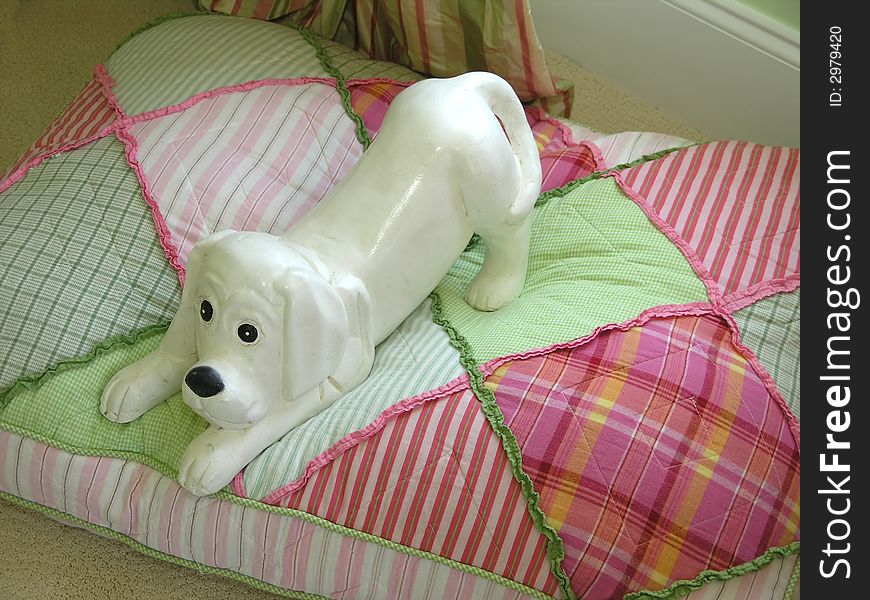 Playful elegant porcelain dog on checkered pillow. Playful elegant porcelain dog on checkered pillow